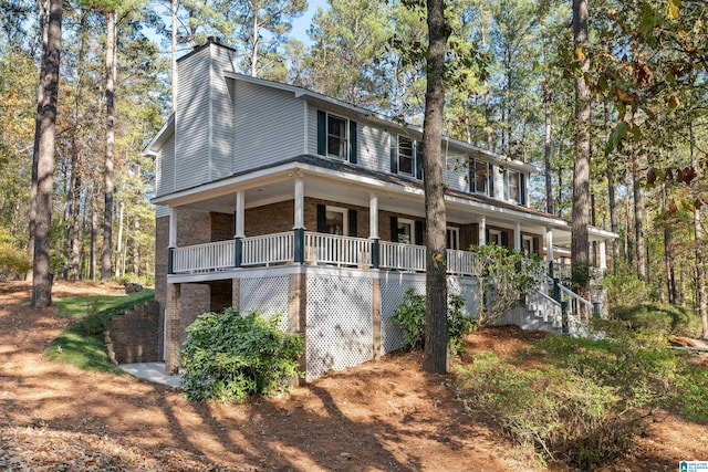 view of side of property featuring covered porch