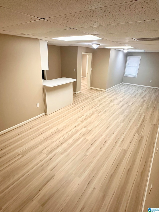 basement with light wood-type flooring and a drop ceiling