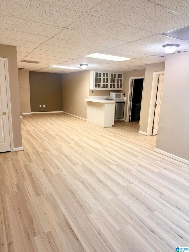 interior space with light hardwood / wood-style flooring and a drop ceiling