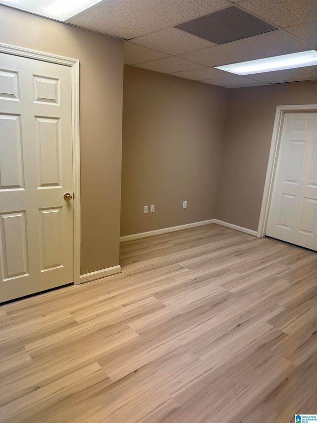 interior space featuring a drop ceiling and light hardwood / wood-style flooring