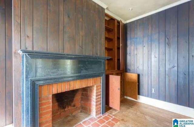 718 Blue Ridge Dr, Anniston, AL 36207 - detailed view of a brick fireplace, ornamental molding, wooden walls, baseboards, and wood finished floors