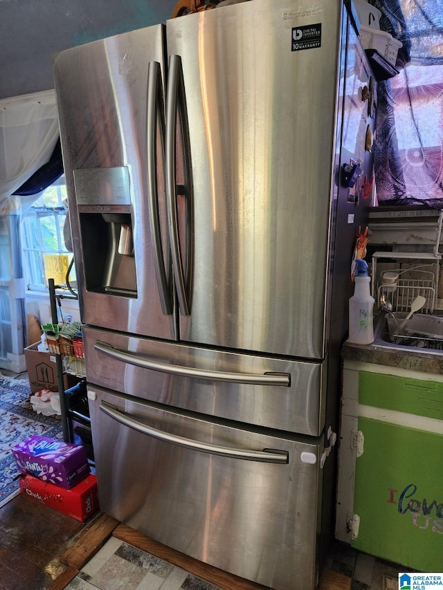 interior details featuring stainless steel fridge with ice dispenser and hardwood / wood-style floors