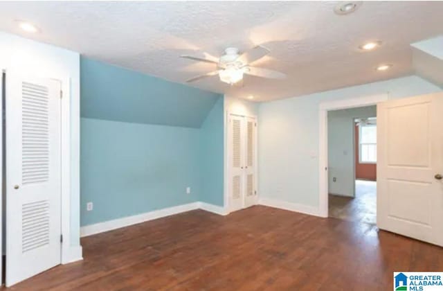 additional living space featuring ceiling fan, dark hardwood / wood-style flooring, and lofted ceiling