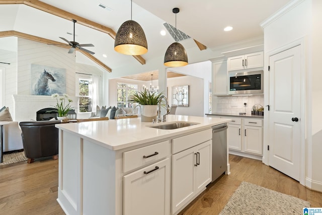 kitchen with appliances with stainless steel finishes, light wood-type flooring, white cabinetry, and sink