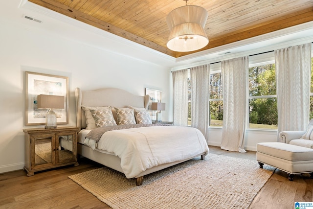 bedroom with crown molding, light hardwood / wood-style flooring, and wood ceiling