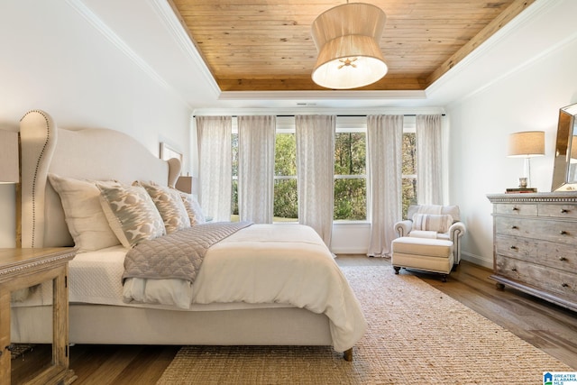 bedroom with ornamental molding, hardwood / wood-style flooring, a tray ceiling, and wood ceiling