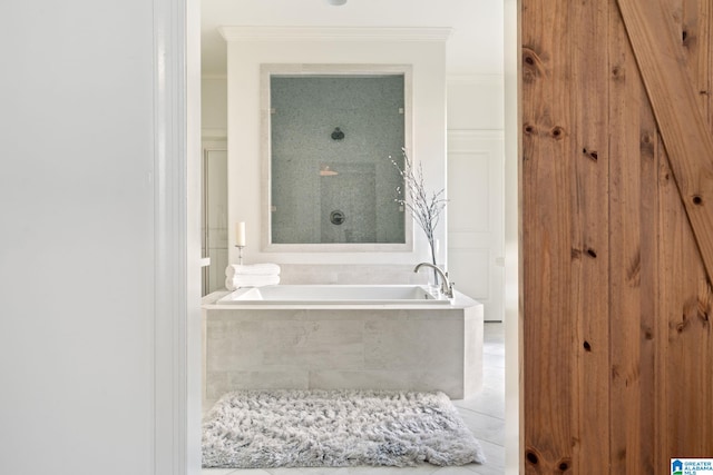 bathroom with tile patterned floors, ornamental molding, and tiled tub