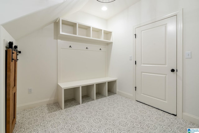 mudroom with a barn door and lofted ceiling