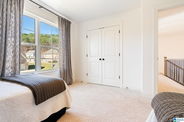 bedroom featuring light colored carpet and a closet