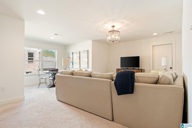 carpeted living room with a chandelier