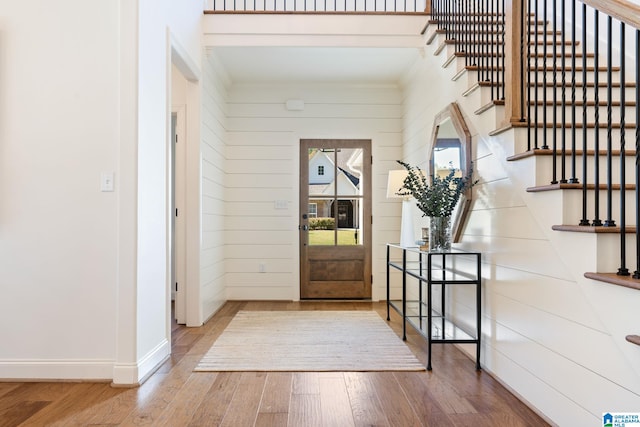 foyer with hardwood / wood-style flooring and wood walls