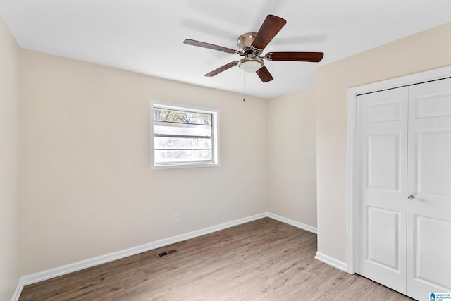 unfurnished bedroom featuring light wood-type flooring, a closet, and ceiling fan