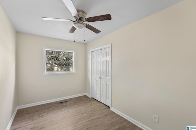 unfurnished bedroom with ceiling fan, a closet, and light hardwood / wood-style flooring