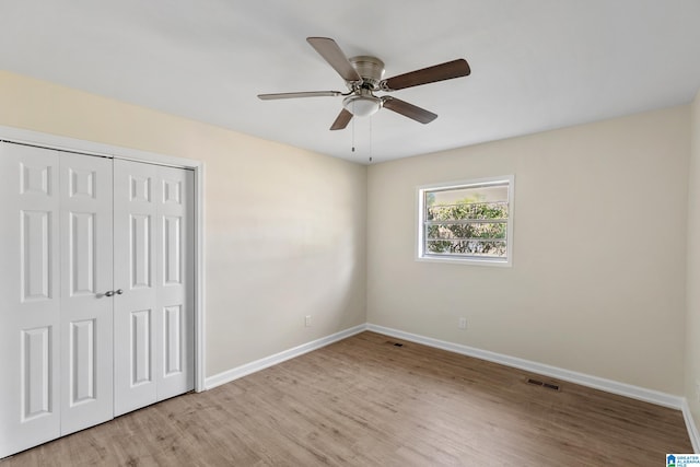 unfurnished bedroom with a closet, light hardwood / wood-style floors, and ceiling fan