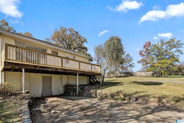 rear view of house featuring a deck and a lawn