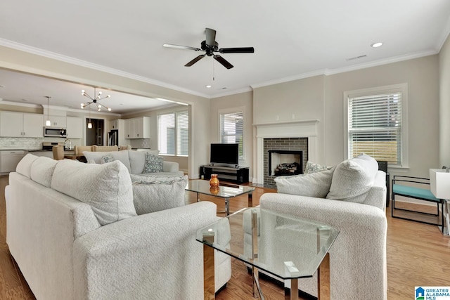 1114 Eagle Nest Cir, Birmingham, AL 35242 - living room featuring a ceiling fan, a brick fireplace, ornamental molding, recessed lighting, and light wood-style flooring