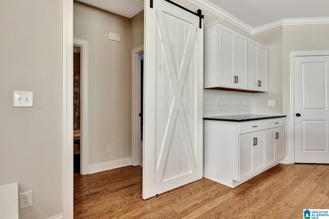 1114 Eagle Nest Cir, Birmingham, AL 35242 - bar area featuring light wood-style flooring, a barn door, tasteful backsplash, baseboards, and crown molding