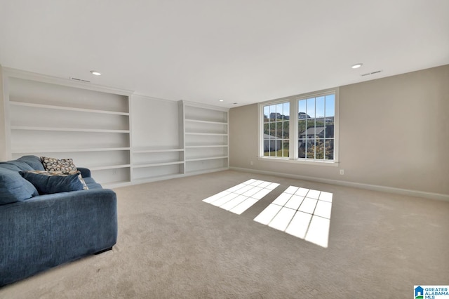 living area featuring built in shelves and light colored carpet