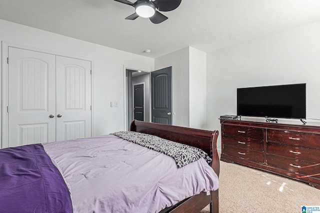 bedroom with ceiling fan, light carpet, and a closet