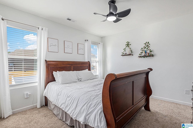 bedroom featuring light colored carpet, multiple windows, and ceiling fan