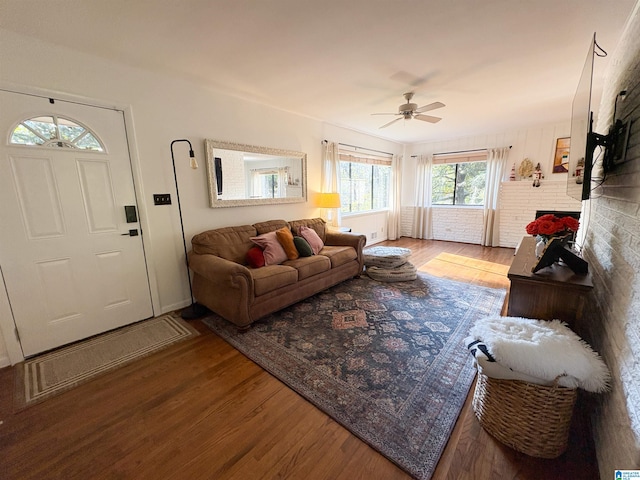 living room featuring ceiling fan, a fireplace, and light hardwood / wood-style floors