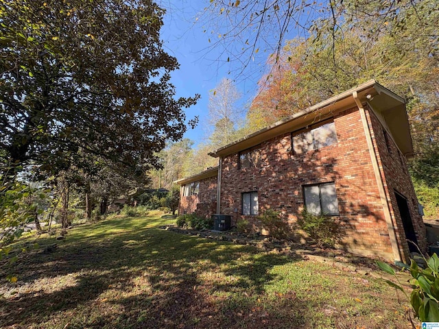 view of side of property featuring a yard, a garage, and central air condition unit