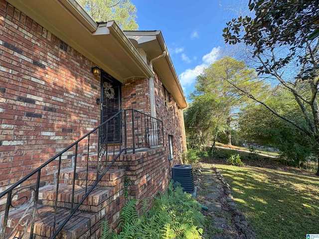 view of property exterior featuring a lawn and central air condition unit