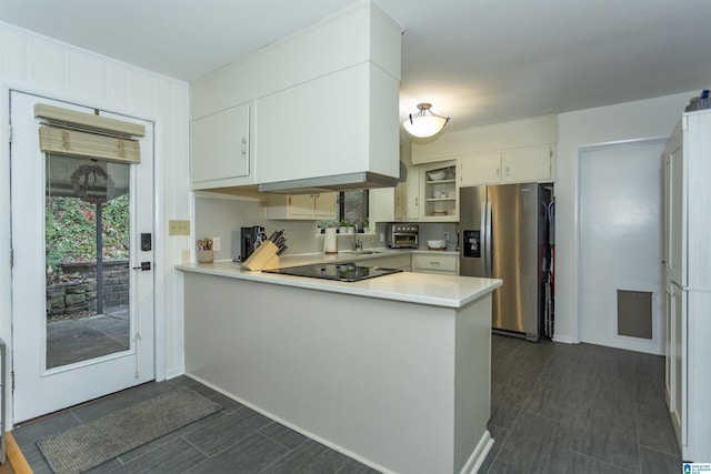 kitchen featuring white cabinets, sink, stainless steel fridge, black electric cooktop, and kitchen peninsula