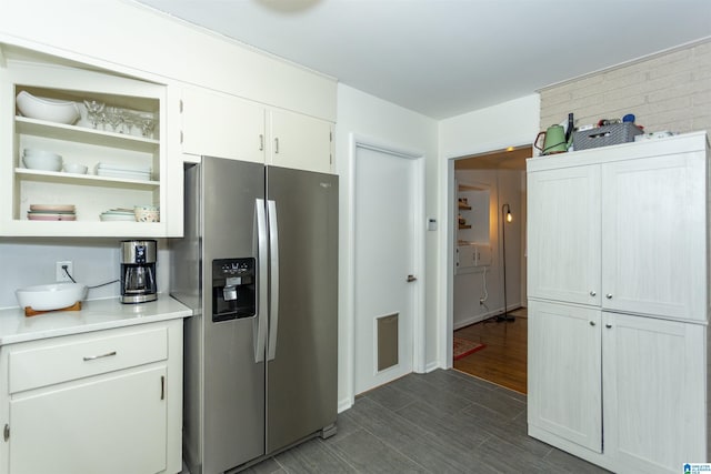 kitchen featuring dark hardwood / wood-style floors, stainless steel fridge, and white cabinetry