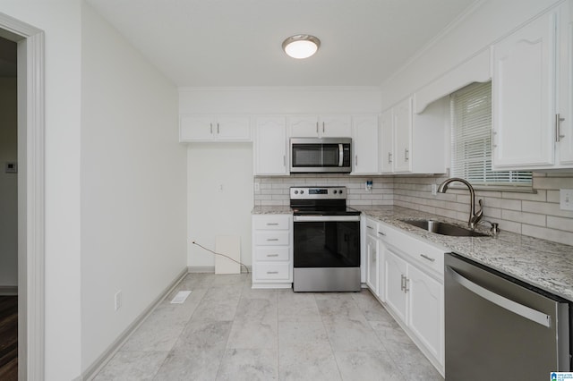 kitchen featuring light stone counters, sink, white cabinetry, and stainless steel appliances