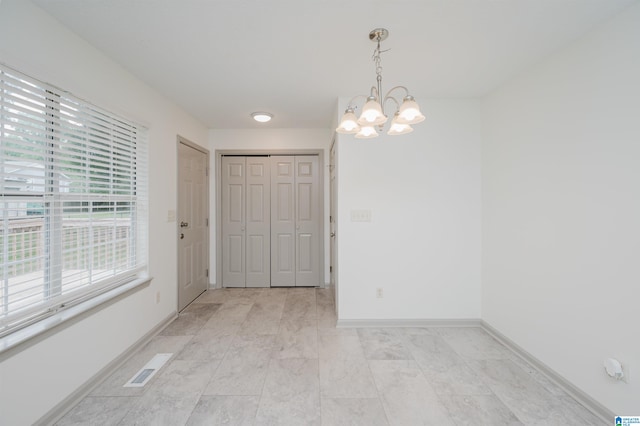 unfurnished dining area with an inviting chandelier