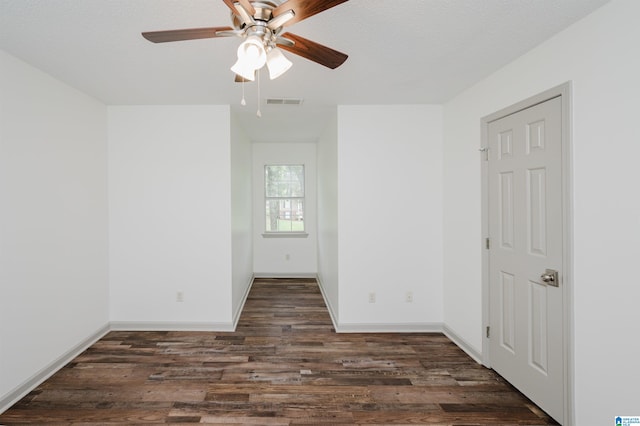 spare room featuring a textured ceiling, ceiling fan, and dark wood-type flooring