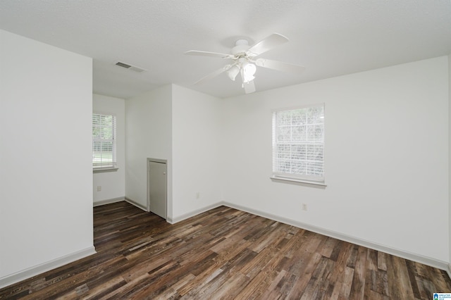 spare room with dark hardwood / wood-style flooring and ceiling fan