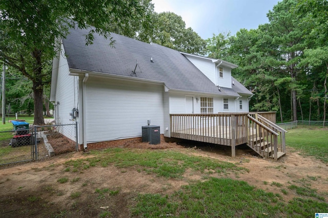 back of property featuring a lawn, cooling unit, and a deck