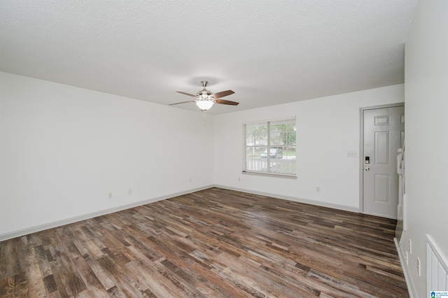 unfurnished room with ceiling fan, dark hardwood / wood-style flooring, and a textured ceiling