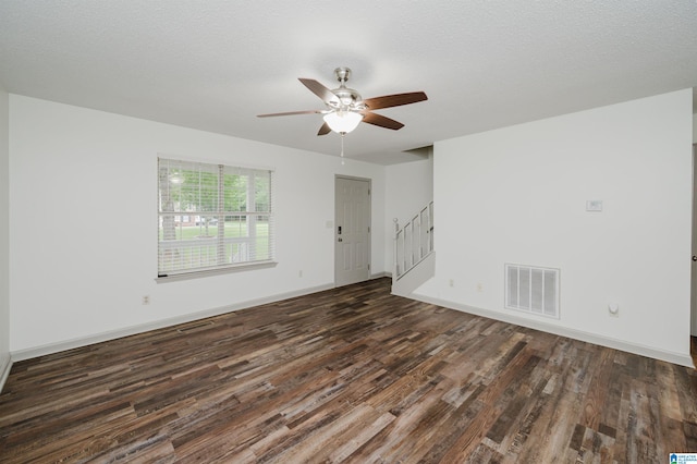 unfurnished room with a textured ceiling, dark hardwood / wood-style floors, and ceiling fan