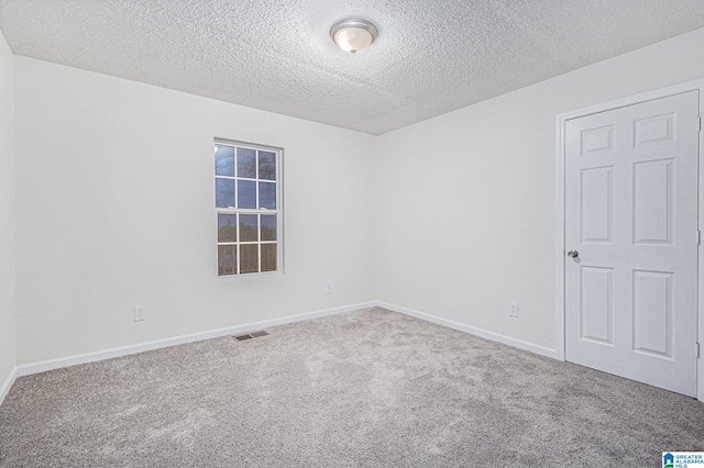 carpeted empty room with a textured ceiling