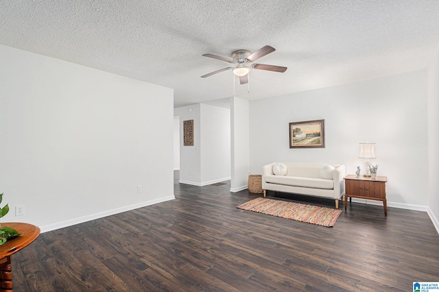 living area with a textured ceiling, ceiling fan, and dark wood-type flooring