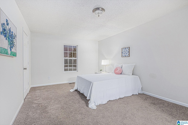 bedroom with a textured ceiling and carpet floors