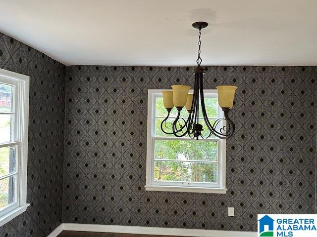 unfurnished dining area with a healthy amount of sunlight and a notable chandelier