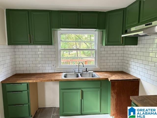 kitchen with sink, green cabinetry, and wood counters