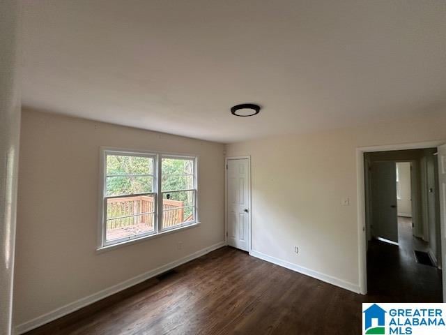 unfurnished bedroom with dark wood-type flooring