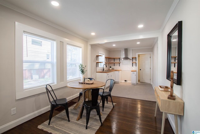 dining area with crown molding, dark hardwood / wood-style flooring, and sink