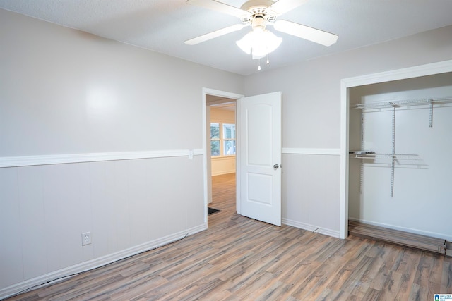 unfurnished bedroom with a closet, ceiling fan, hardwood / wood-style floors, and a textured ceiling