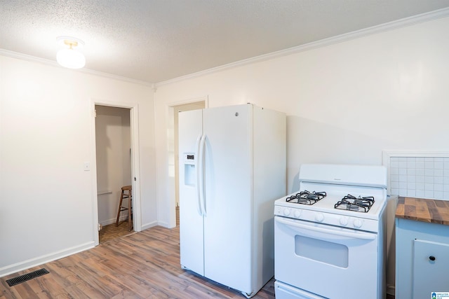 kitchen with wood counters, white appliances, crown molding, light hardwood / wood-style flooring, and a textured ceiling