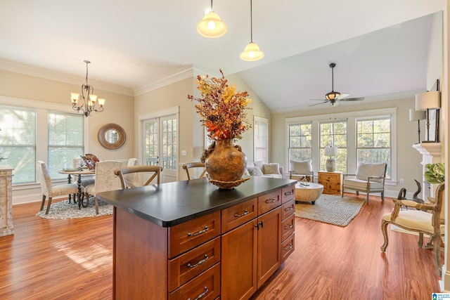 kitchen featuring ceiling fan with notable chandelier, vaulted ceiling, hanging light fixtures, and light hardwood / wood-style flooring