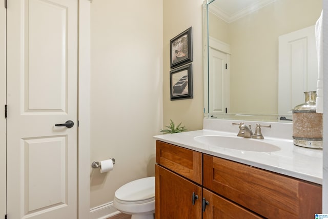 bathroom with vanity, toilet, and ornamental molding