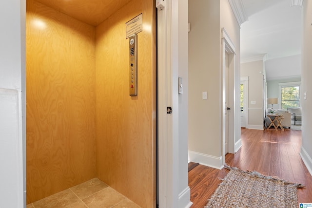 hall with dark hardwood / wood-style flooring, elevator, and ornamental molding