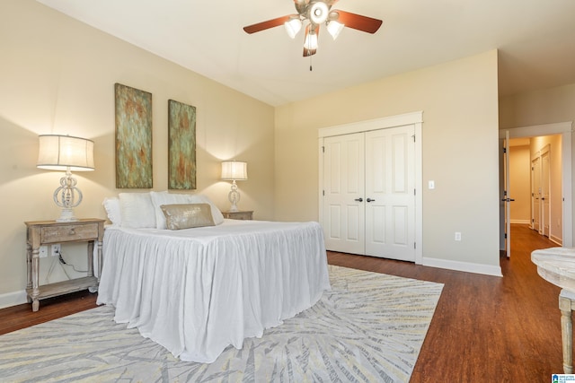 bedroom with a closet, dark wood-type flooring, and ceiling fan