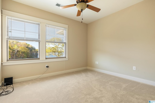 spare room with ceiling fan and light colored carpet